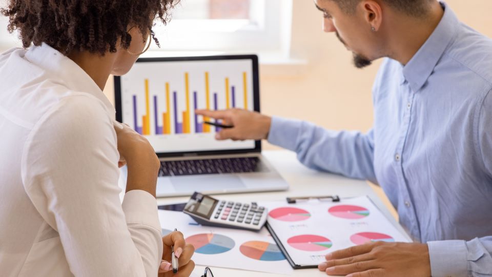 Analysts review statistical charts in the office