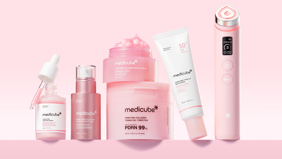 تُظهر الصورة ستة منتجات من ماركة Medicube، بما في ذلك السيروم وكريم الوقاية من الشمس وجل التونر وكريم الكولاجين، بالإضافة إلى جهاز DERMA-S المحمول باليد، وكلها معروضة على خلفية وردية.