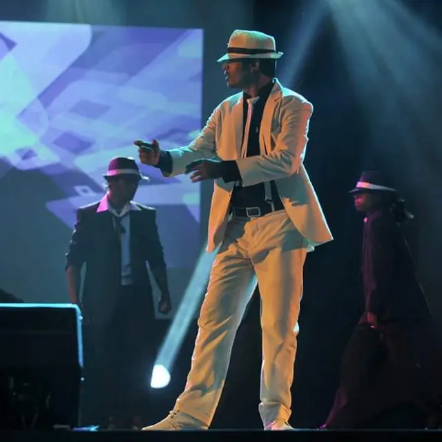 Ravee Farooq performing a dance in a white suit