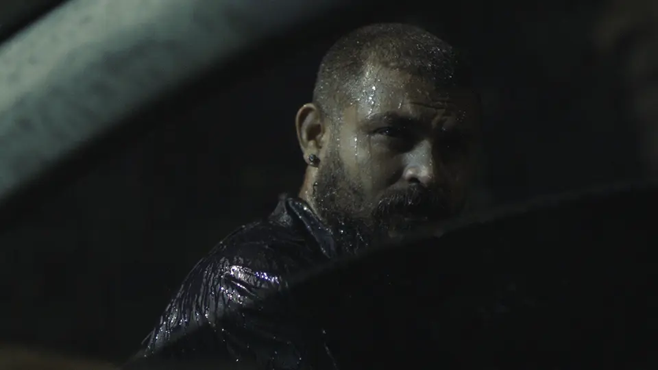 Still shot of a man drenched in rain from Shamin Nizam's award-winning movie Vishka
