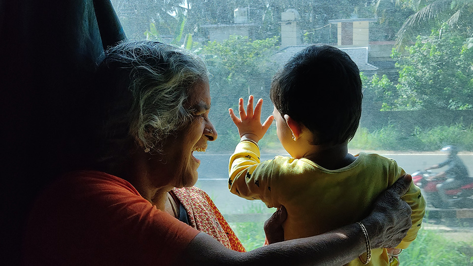 Woman holding a child in front of a window