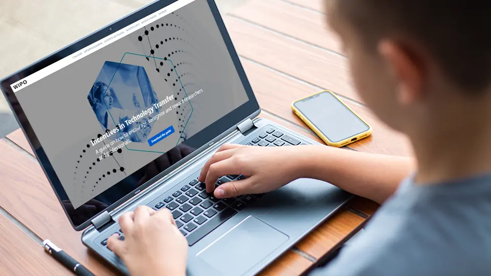 Man reading a WIPO guide on a laptop